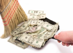 Money being swept into dustpan with broom