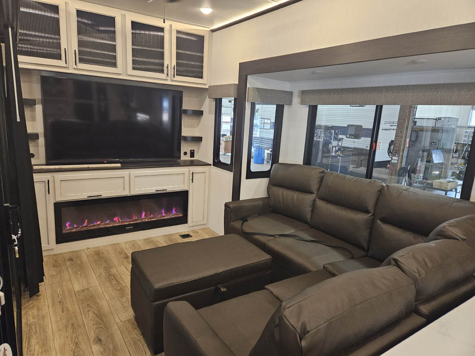 Sabre 33RLP living area with sectional and fireplace