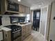 Kitchen cabinets, stove, and microwave in 2027 Flagstaff Micro Lite 22FBS