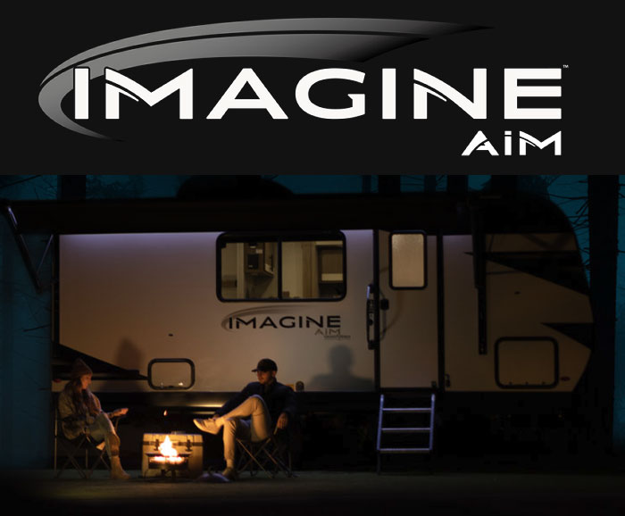 Photo of Imagine AIM travel trailer in dark woods with logo above.