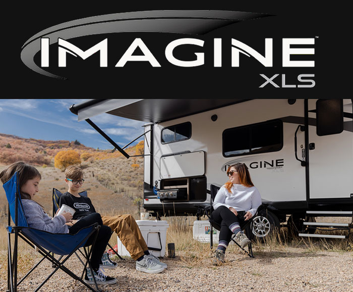 Photo of Grand Design Imagine XLS travel trailer with family sitting under awning. 