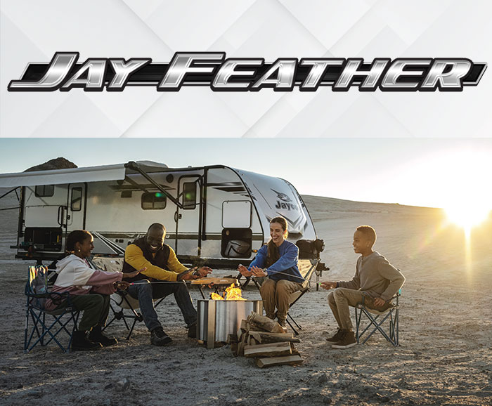 Photo of family gathered around a campfire in front of Jayco Jay Feather travel trailer, with logo above.