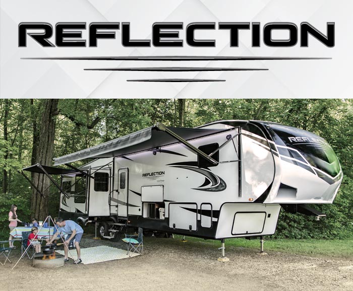 Photo of Grand Design Reflection fifth wheel parked in wooded area with logo above. 